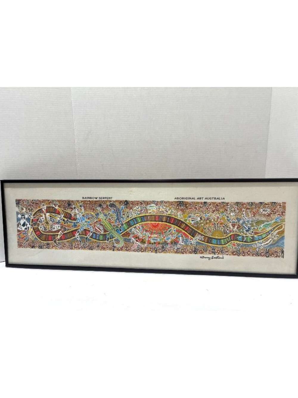framed textile artwork titled "Rainbow Serpent" by Aboriginal artist Danny Eastw